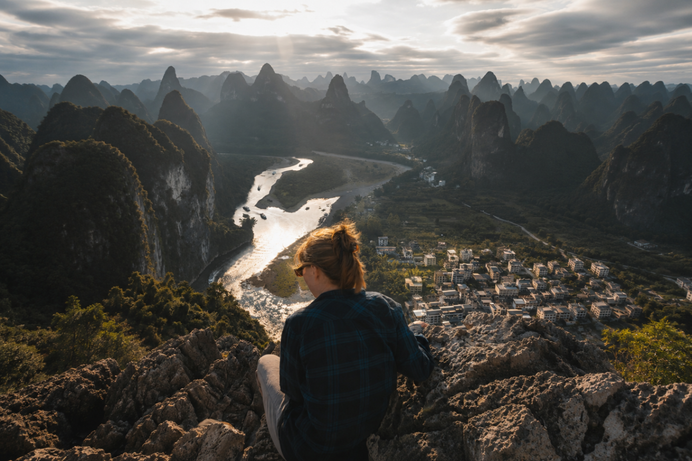 An illustrated view of a person overlooking a Li river winding through karst mountain peaks at dawn in Yangshuo, Guangxi